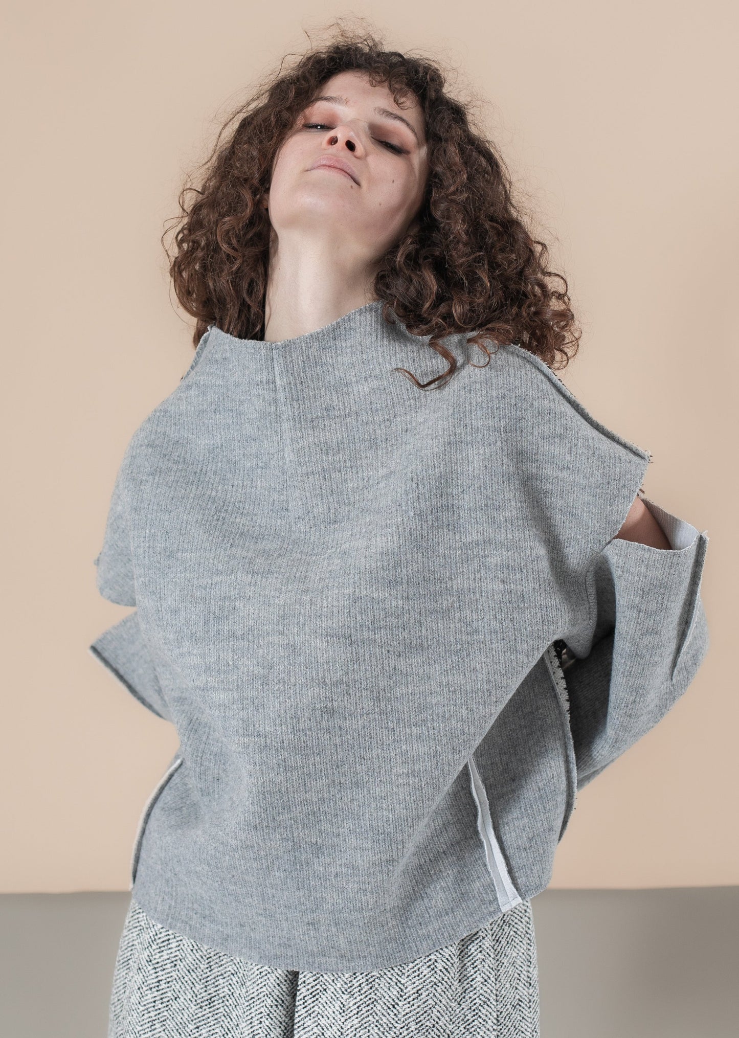 Gray open shoulder sweater with an ornament