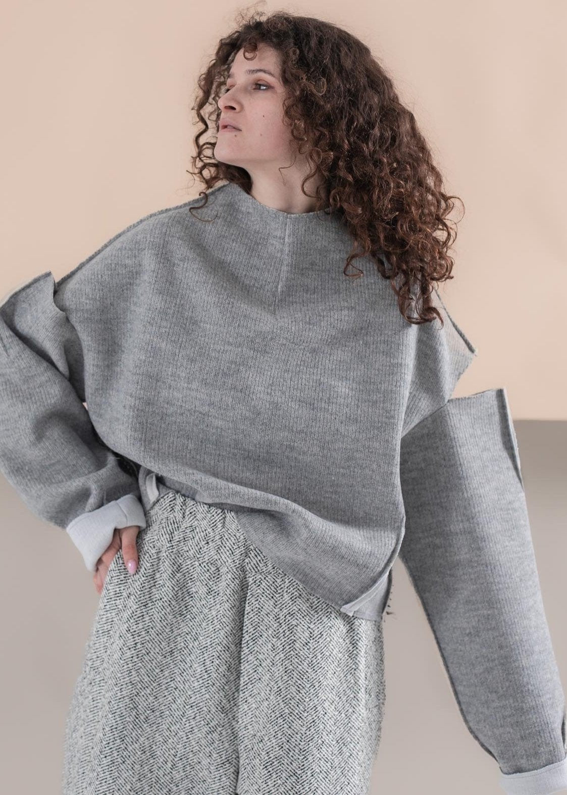 Gray open shoulder sweater with an ornament