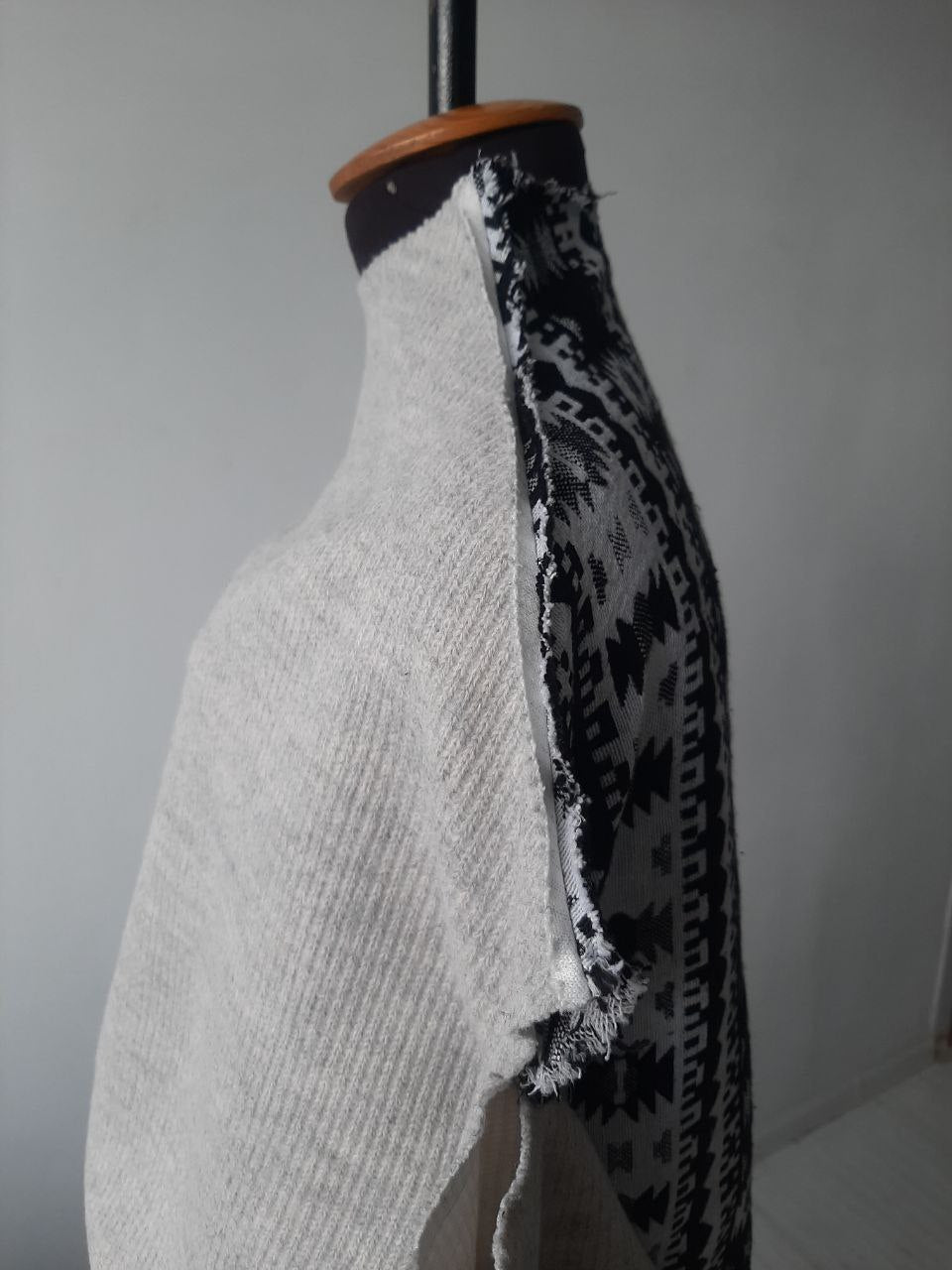 Gray open shoulder sweater with an ornament